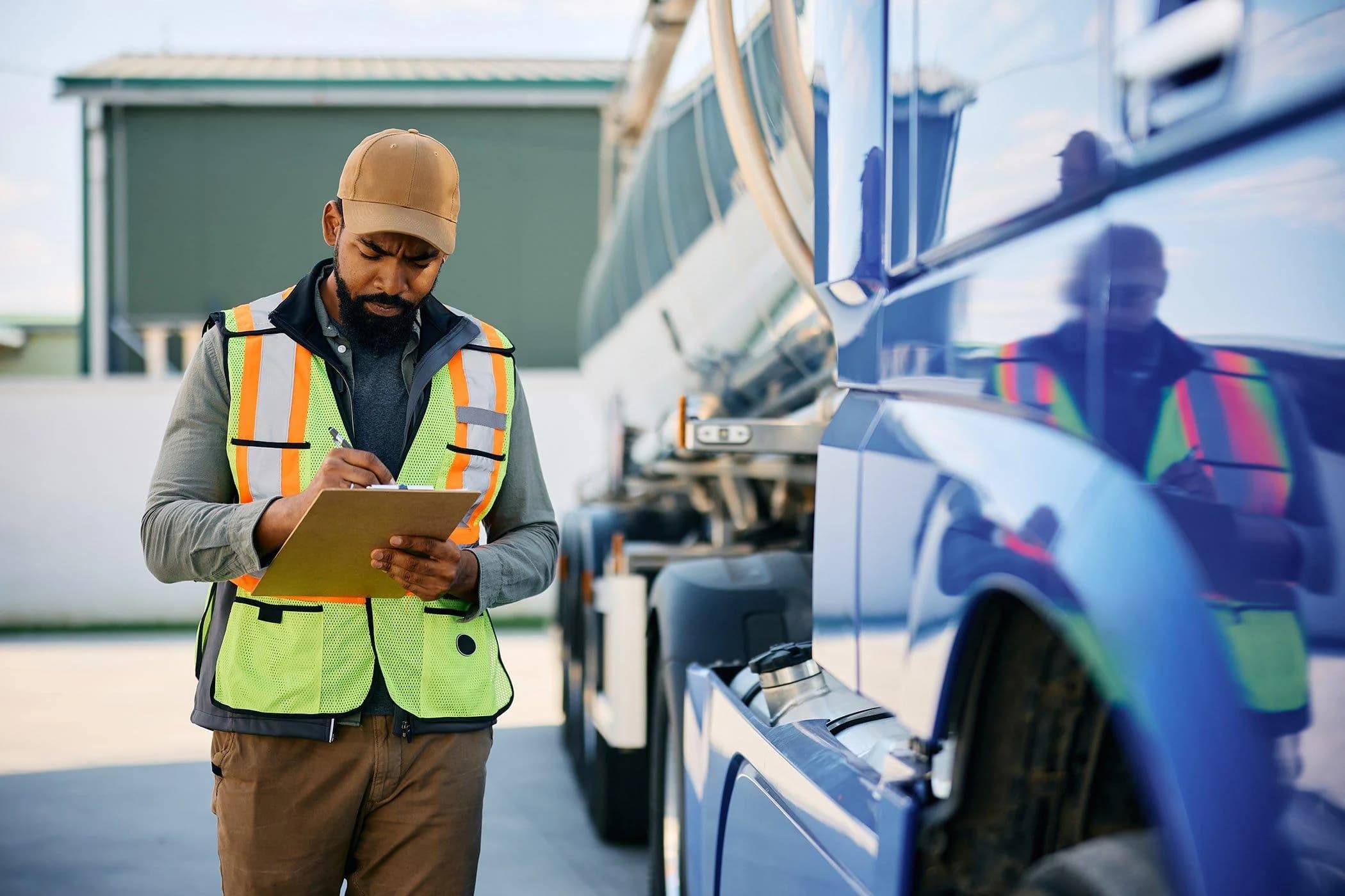 Fleet inspector assessing a blue semi-truck before its wash service.